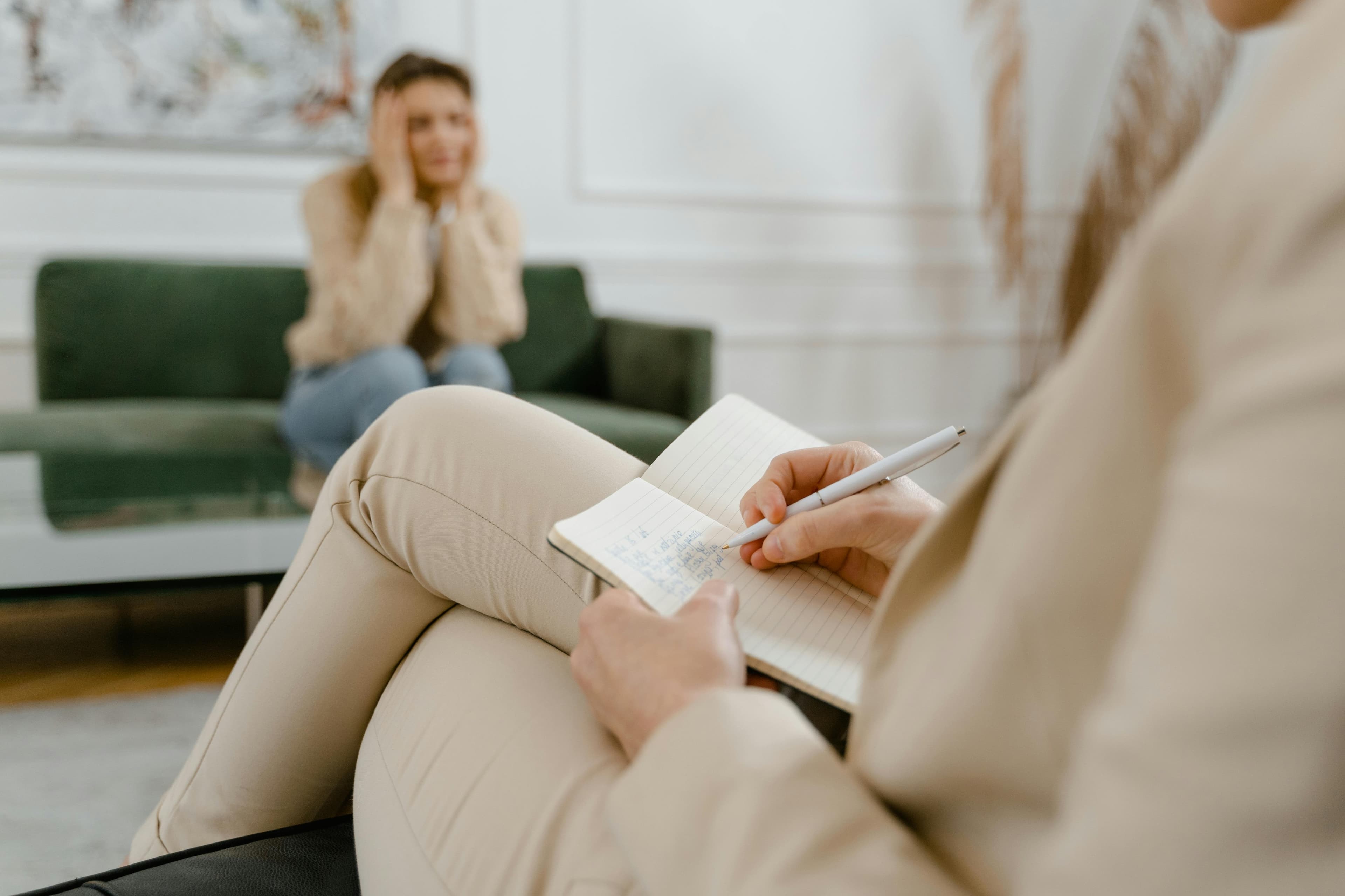 Mental health care professional listening and taking notes in a supportive session
